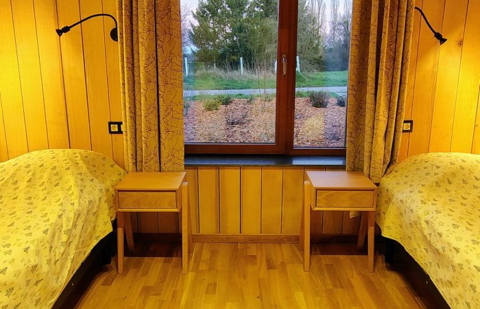 Deux lits individuels (2*90cm) occupent cette grande chambre du rez-de-chaussée, elle aussi parfaitement accessible. Ici, c’est le frêne qui a été choisi pour bercer vos nuits. Si vous le souhaitez, vous pouvez louer (par exemple chez Qualias) un lit médicalisé, nous retirerons alors un des lits afin que vous ayez suffisamment de place. Deux lits individuels (2*90cm) occupent cette grande chambre du rez-de-chaussée, elle aussi parfaitement accessible. Ici, c’est le frêne qui a été choisi pour bercer vos nuits. Si vous le souhaitez, vous pouvez louer (par exemple chez Qualias) un lit médicalisé, nous retirerons alors un des lits afin que vous ayez suffisamment de place.